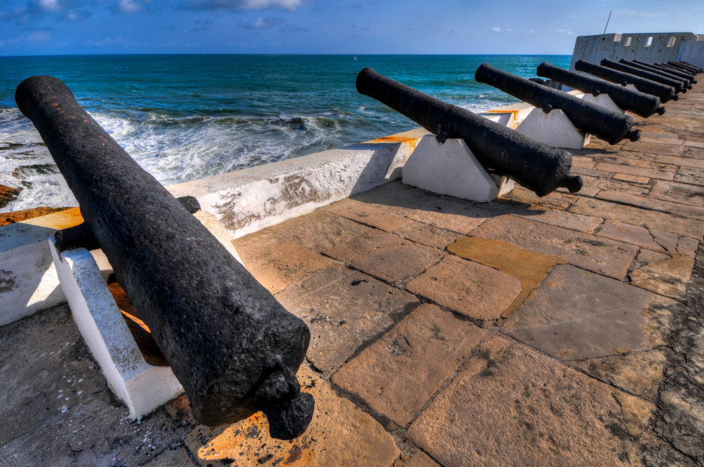 A group of cannons sitting on top of a stone wall.