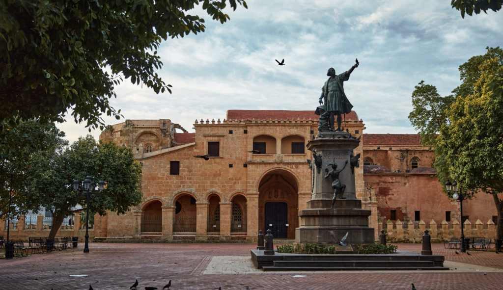 A statue of a man in front of an old building.